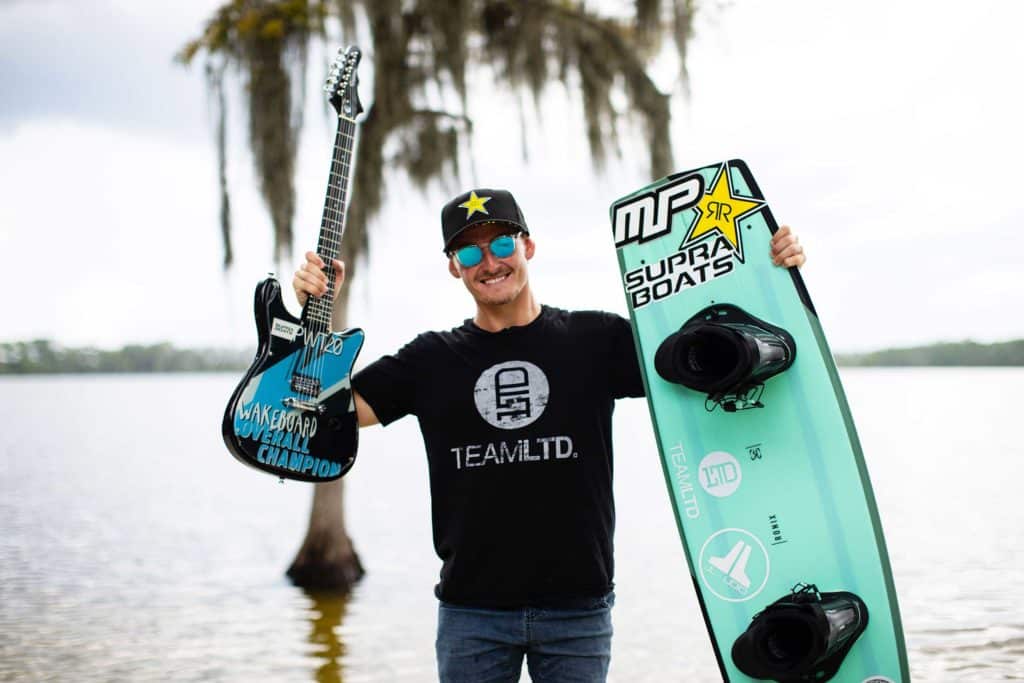 Nic Rapa holding up his guitar trophy